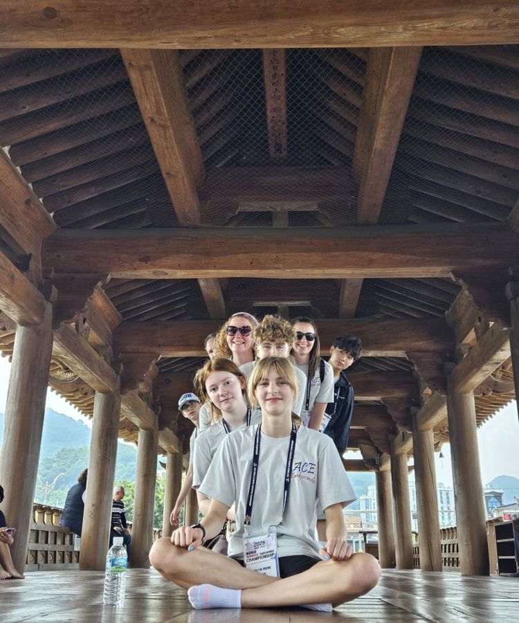 ACE students sitting together under a traditional wooden Korean pavilion
